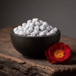 wild-rose-treasury-collection-incense-4 A dark soapstone bowl of handcrafted Wild Rose incense from the Treasury Collection, with a single, deep crimson wild rose beside it.